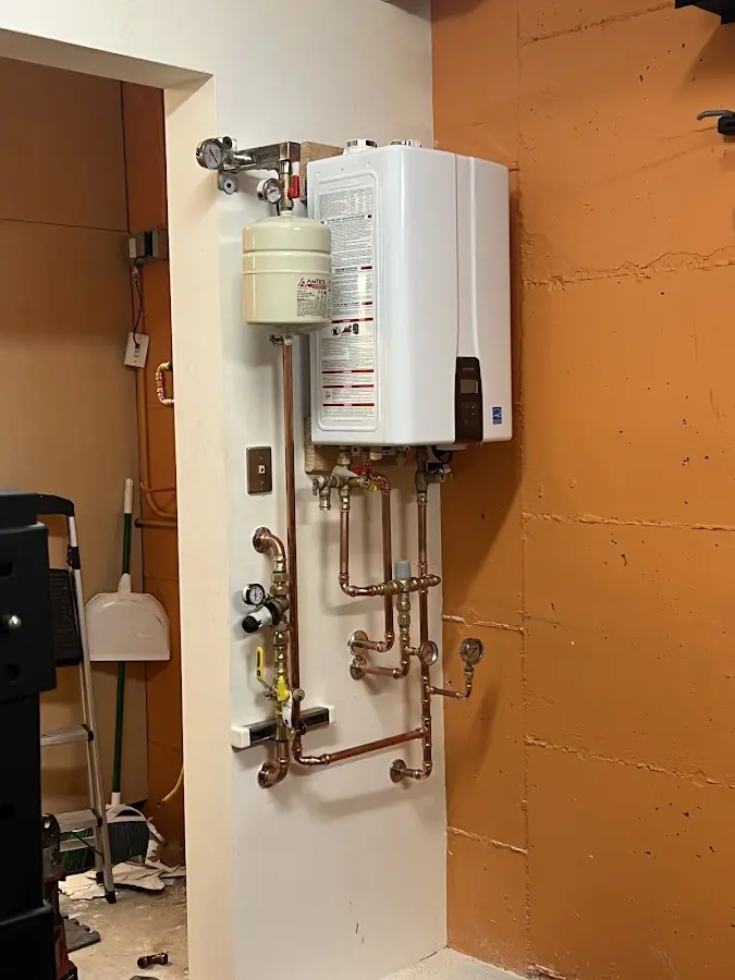 Plumbing technician inspecting water heater connections in North Little Rock